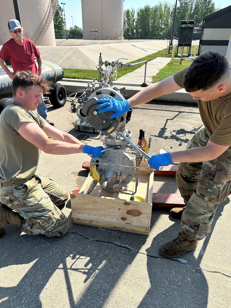 2 service members work on a hydrant valve.