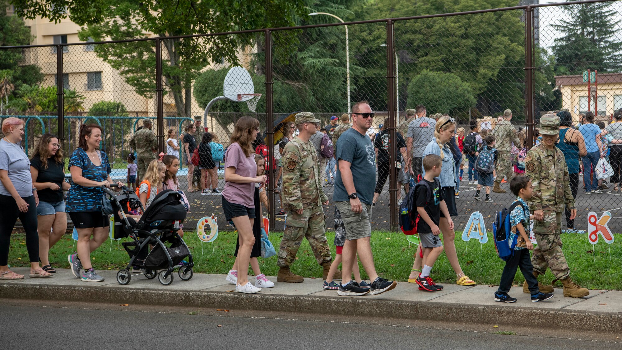 Parents and community members walk students into school.