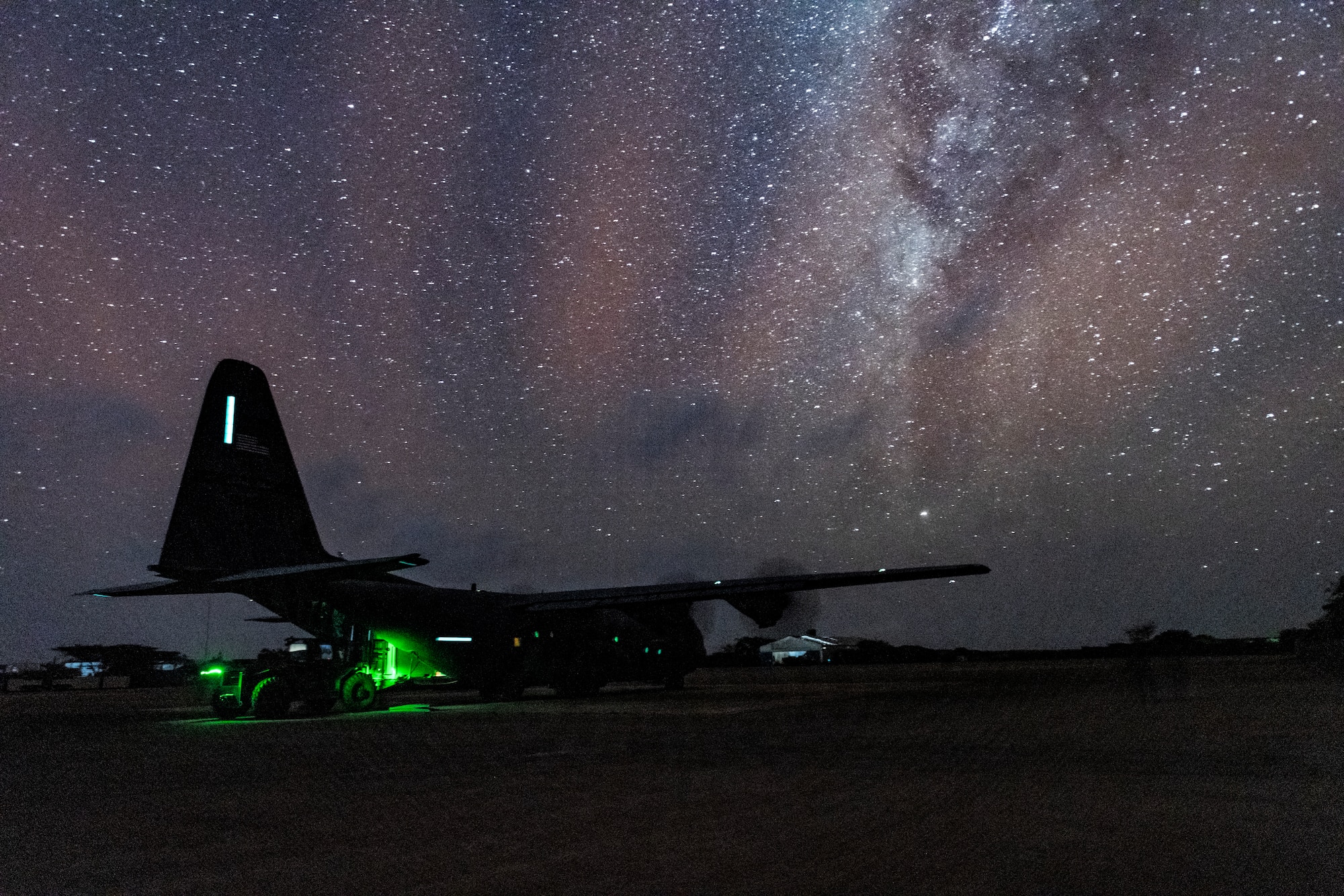 Photo of a cargo plane receiving cargo at night