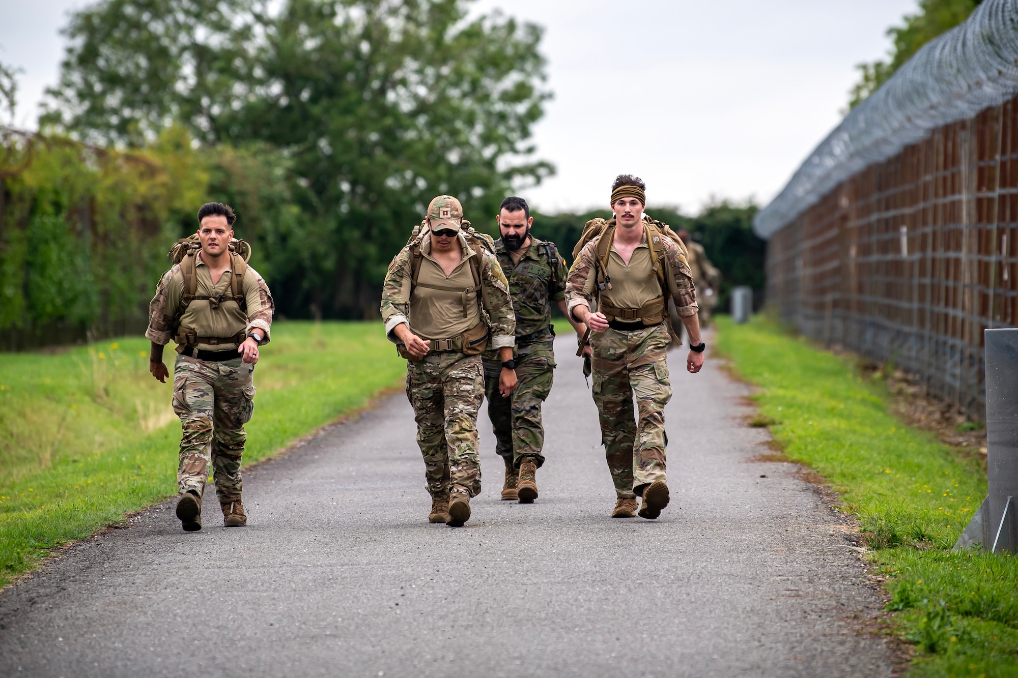 Participants complete a ruck march at RAF Molesworth, England, Aug. 18, 2023. Over 100 personnel from the 501st CSW and mission partner units participated in a 25 Kilometer Danish Contingent ruck march, which allowed them to test their physical capabilities and encouraged social bonds between joint forces. The DANCON ruck march has been completed in numerous countries throughout the world since it was established in 1972. (U.S. Air Force photo by Staff Sgt. Eugene Oliver)