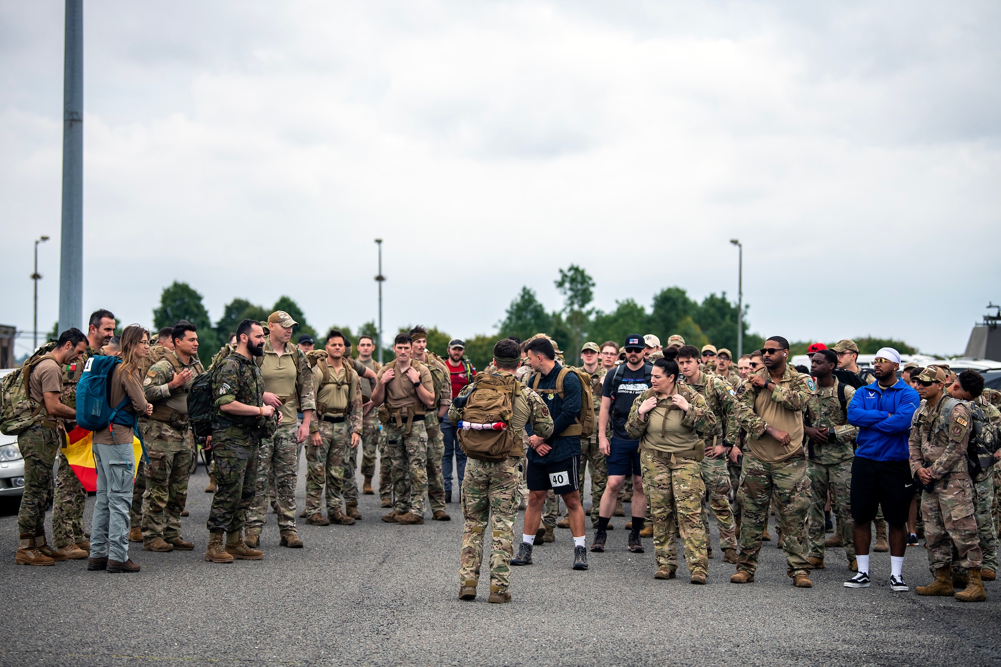 Staff Sgt. Josten Lacey, center, 423d Security Forces Squadron Assistant NCO in Charge of training, briefs ruck march participants at RAF Molesworth, England, Aug. 18, 2023. Over 100 personnel from the 501st CSW and mission partner units participated in a 25 Kilometer Danish Contingent ruck march, which allowed them to test their physical capabilities and encouraged social bonds between joint forces. The DANCON ruck march has been completed in numerous countries throughout the world since it was established in 1972. (U.S. Air Force photo by Staff Sgt. Eugene Oliver)