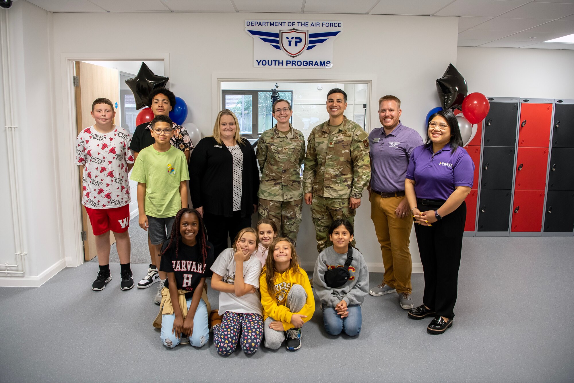 Teens and 501st Combat Support Wing members pose for a photo at RAF Alconbury, England, Aug. 18, 2023. The 423d Force Support Squadron opened a new teen center to provide children on base a place to interact after school. The teen center was reestablished to provide youth on base an additional outlet for social interaction and entertainment. (U.S. Air Force photo by Staff Sgt. Eugene Oliver)