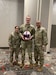 Three Soldiers pose for a photo to show award received.