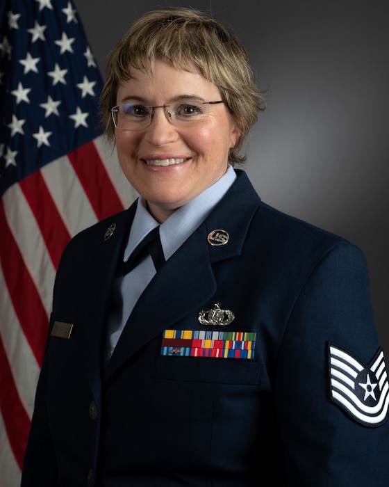 Official photo of TSgt Helena Giammarco with American flag over right shoulder