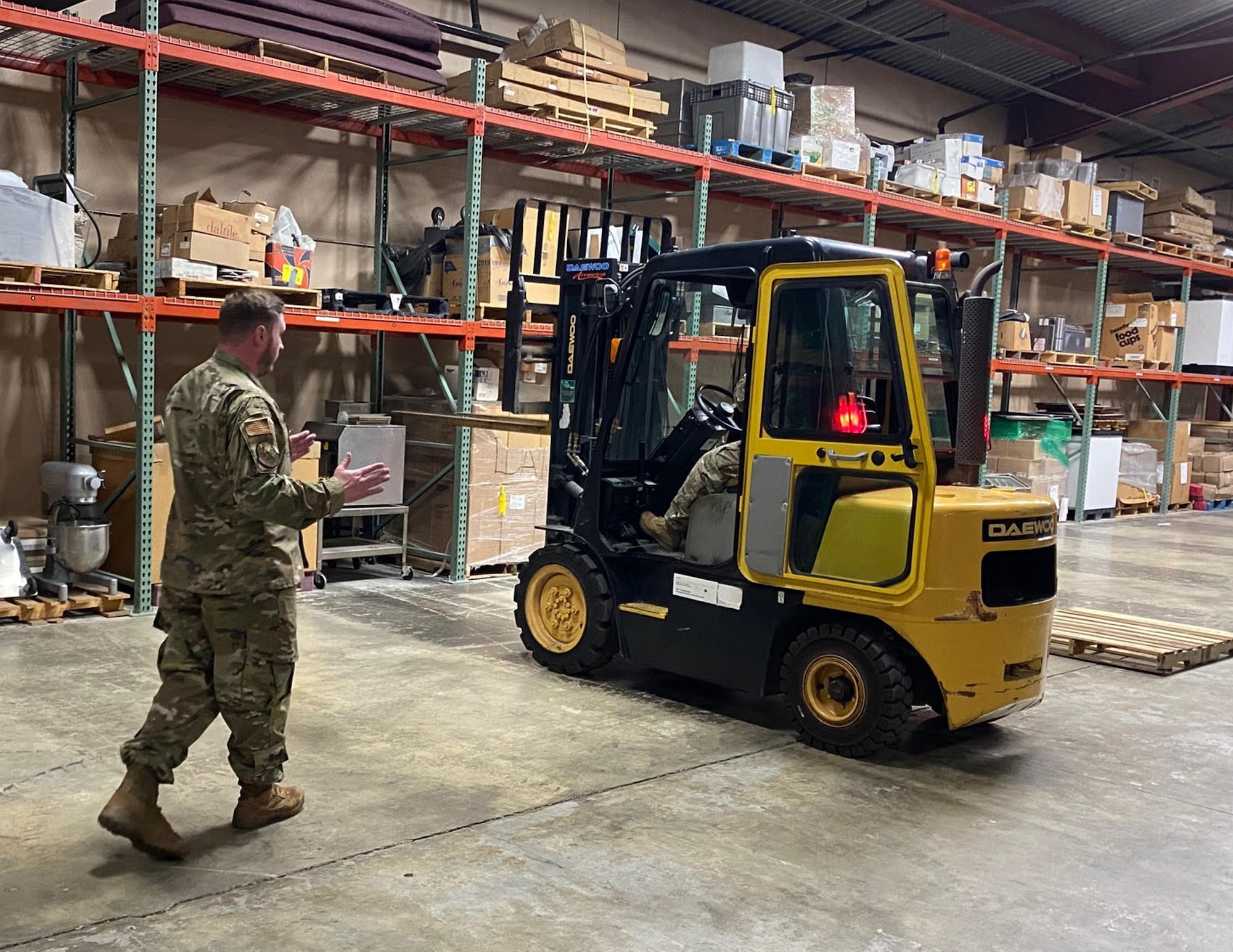 U.S. Air Force Tech. Sgt. Nathan Fuchs, left, gives driving directions to Master Sgt. Esther McRae, 133rd Forces Support Squadron, on how to use the 6K forklift at Joint Base Elmendorf-Richardson, Alaska, July 28, 2023.
