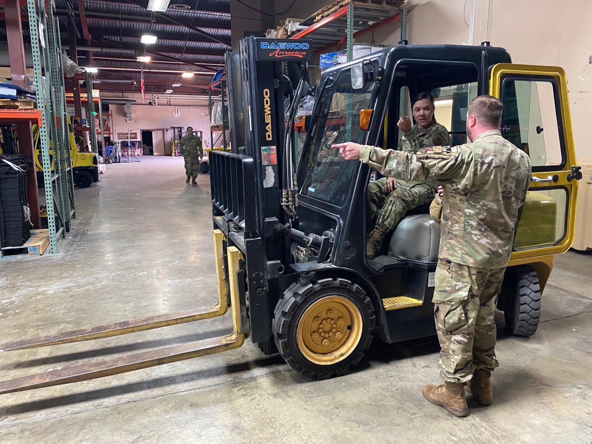 U.S. Air Force Master Sgt. Esther McRae, left, 133rd Force Support Squadron, receives instructions from Tech. Sgt. Nathan Fuchs, right, on how to use the 6K forklift at Joint Base Elmendorf-Richardson, Alaska, July 28, 2023