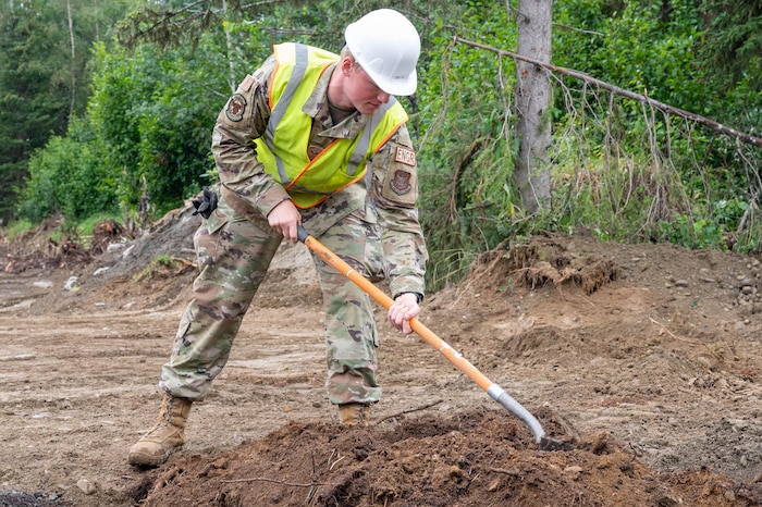 Senior Airman Nathan Smith, 934th Civil Engineer Squadron engineering apprentice, backfills a hole set up for a new transformer at Joint Base Elmendorf-Richardson, Alaska, Aug. 9, 2023. The hole must be filled with dirt so the rest of the electrical can be placed over the top. (U.S. Air Force photo by Senior Airman Colten Tessness)