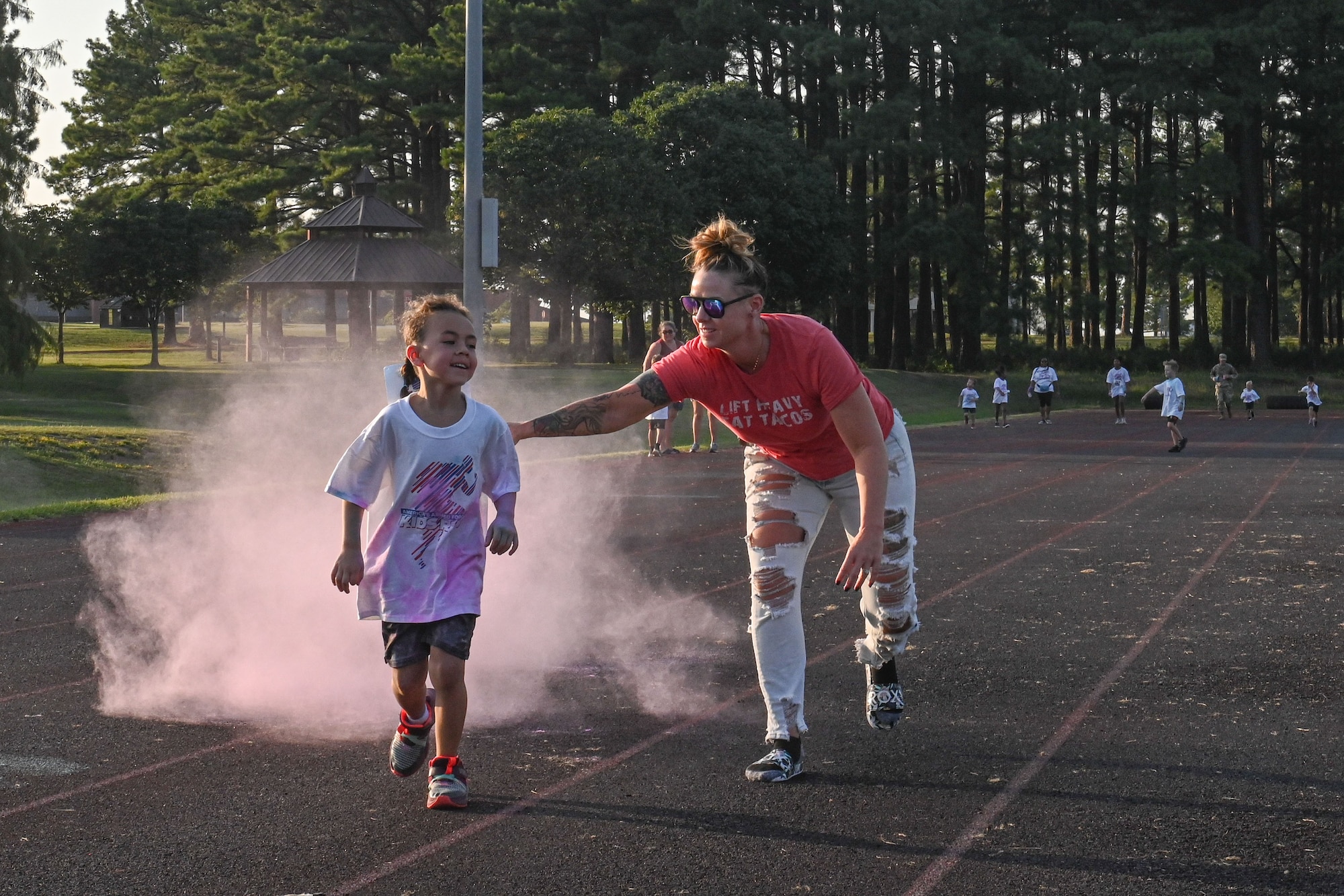 a Team Little Rock member tosses colored powder on a child