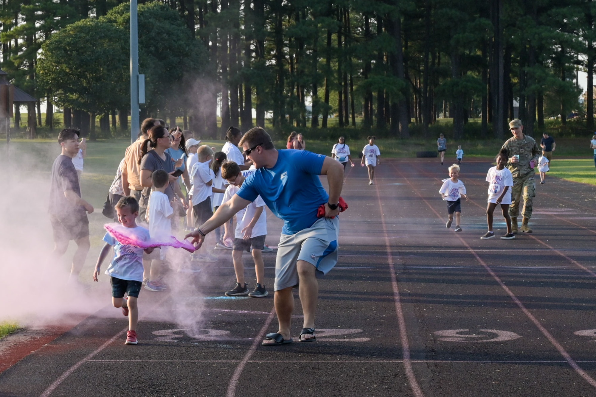 A parent tosses colored powder on a child