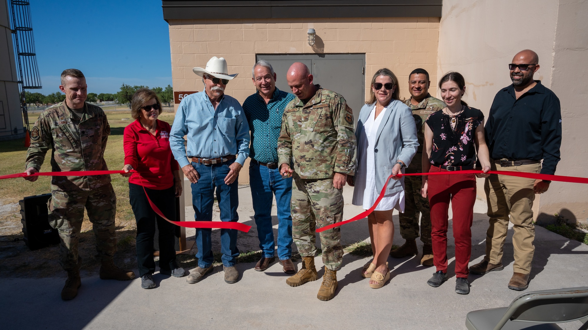 U.S. Air Force Col. Kevin Davidson (center), 47th Flying Training Wing commander, cuts the ribbon during the opening ceremony of the improved airfield lighting vault while surrounded by community partners at Laughlin Air Force Base, Texas, Aug. 18, 2023. Both the Del Rio  and Val Verde County communities have worked with Laughlin over the past several months to ensure that this lighting project is able to come to fruition. (U.S. Air Force photo by Senior Airman Nicholas Larsen)