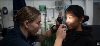 HM3 Kimberly Glanville conducts a flight deck physical on Airman Pia Marie Viray aboard USS Nimitz (CVN 68).