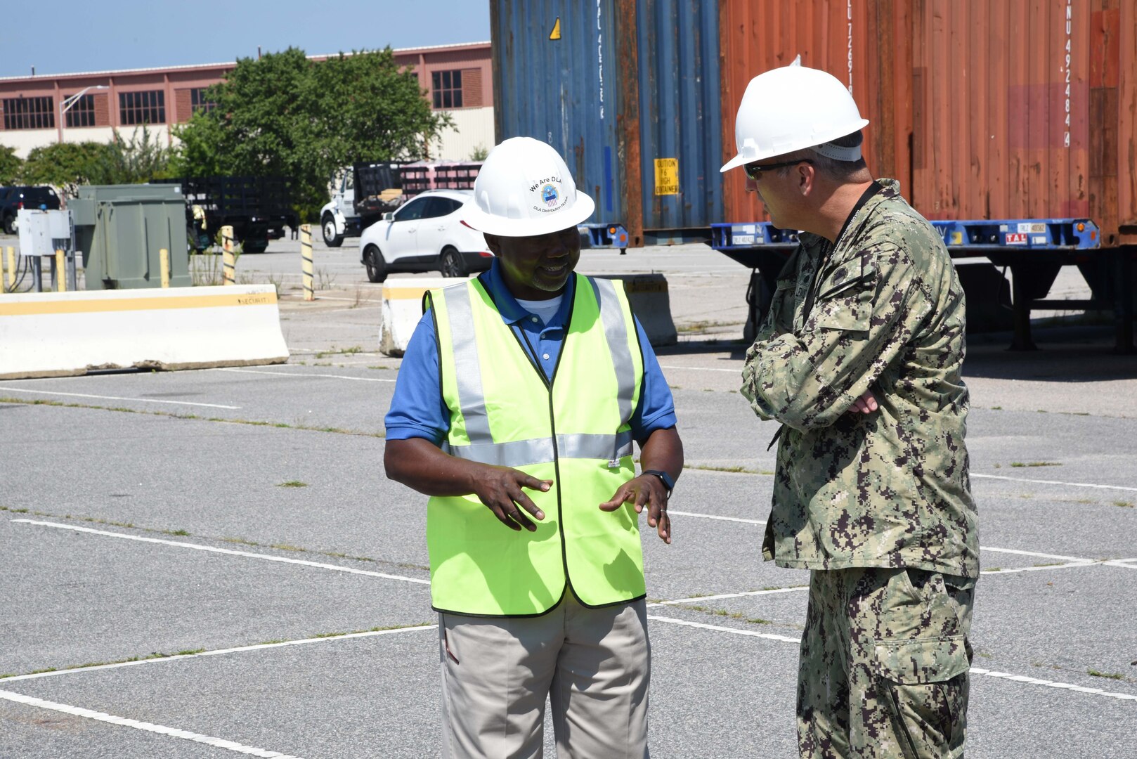 Photo shows two men talking, one in a military uniform.