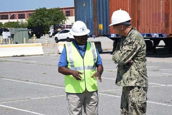 Photo shows two men talking, one in a military uniform.