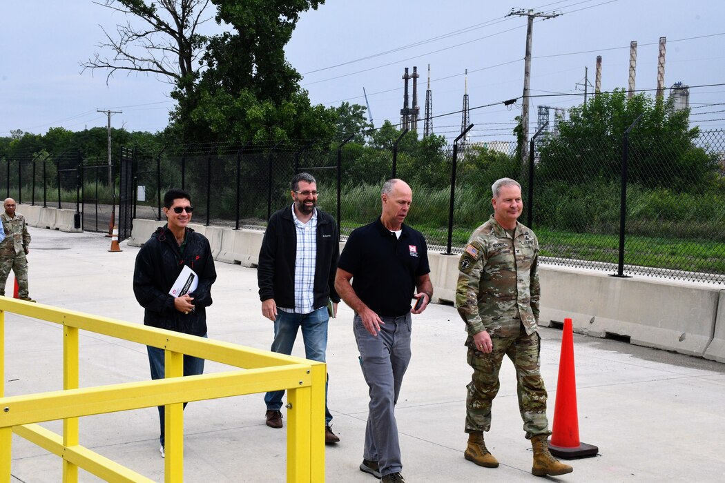 Four men walk outside during a walking tour of a Chicago District site.