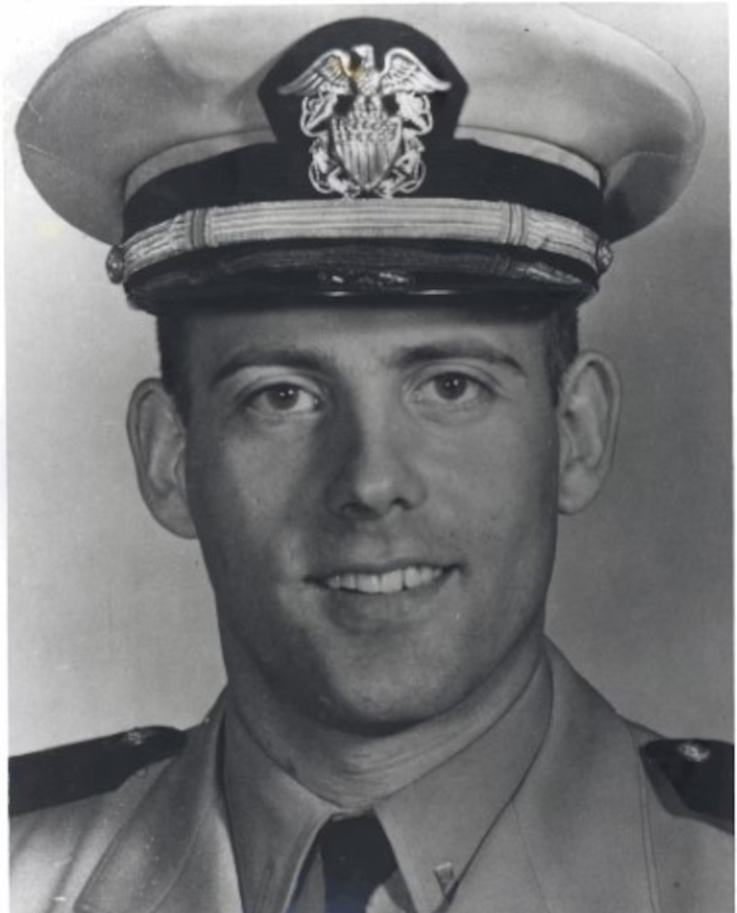 A naval officer poses for a photo.