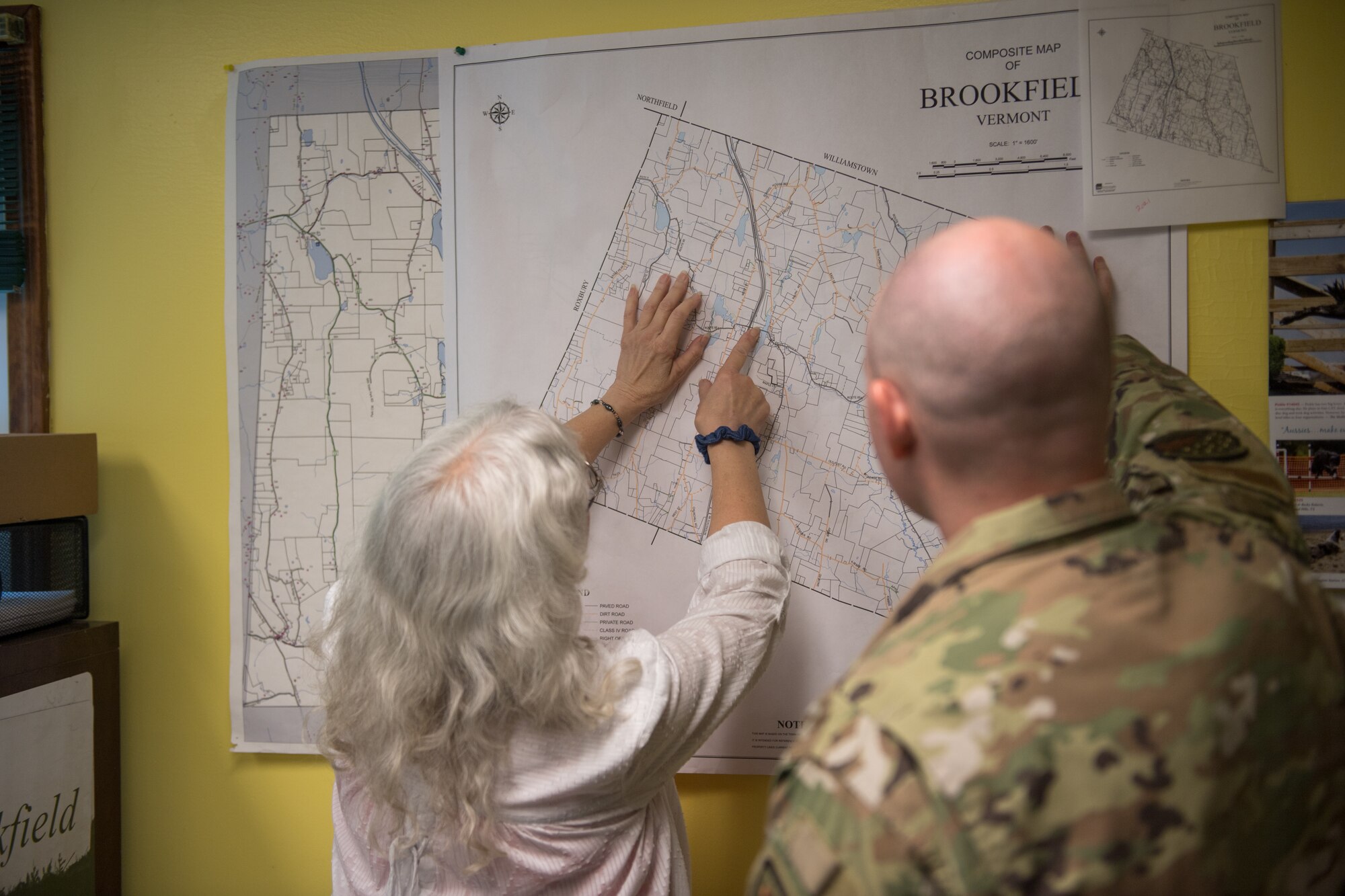 Photo of Brookfield Vermont town treasurer, Amy Ingrassia, pointing to sections of a map that were recently impacted by historic Vermont flooding at Brookfield town offices in Brookfield, Vermont, July 19, 2023. The purpose of the Liaison Officer mission is to meet with town leaders and report information from the town back to the state for possible resourcing. (U.S. Air Force photo by Tech. Sgt. Richard Mekkri)