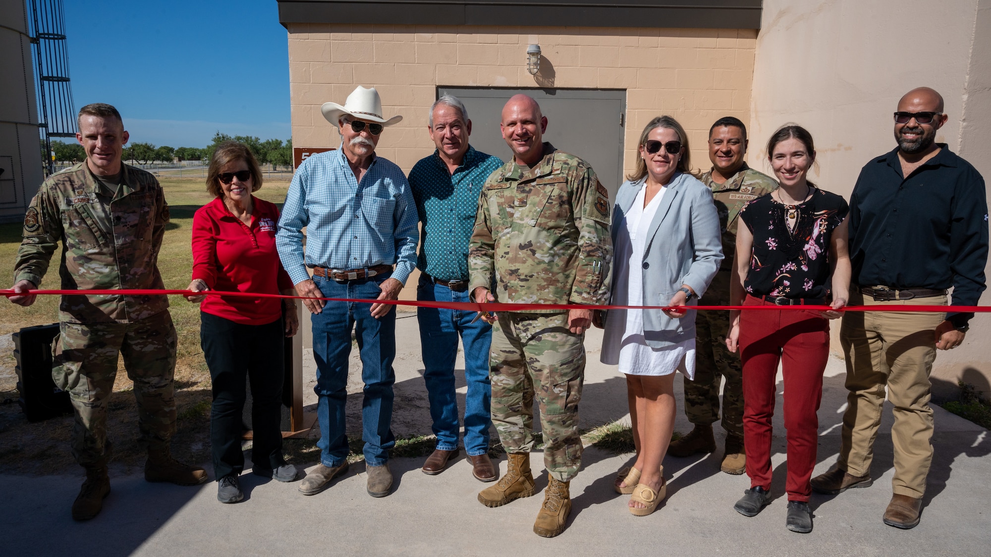 U.S. Air Force Col. Kevin Davidson (center), 47th Flying Training Wing commander, prepares to cut the ribbon during the opening ceremony of the improved airfield lighting project while surrounded by community partners at Laughlin Air Force Base, Texas, Aug. 18, 2023. The Del Rio and Val Verde County communities have worked with Laughlin for the past several months to ensure this lighting project came to fruition. (U.S. Air Force photo by Senior Airman Nicholas Larsen)