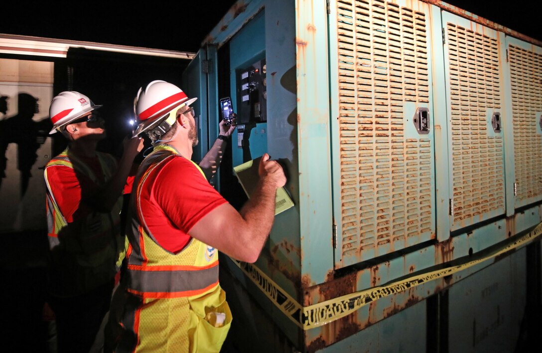Jon Runnels  (foreground) and Kenny Kwan (background), quality assurance representatives deployed with the U.S. Army Corps of Engineers Temporary Emergency Power Team, perform a quality assurance inspection of a generator at a water pump station on Maui, Aug 22. The USACE  is working in partnership with the local and federal response to the Hawaii Wildfires.