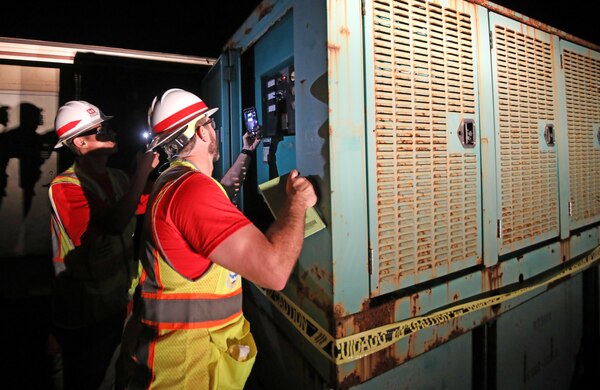 Jon Runnels  (foreground) and Kenny Kwan (background), quality assurance representatives deployed with the U.S. Army Corps of Engineers Temporary Emergency Power Team, perform a quality assurance inspection of a generator at a water pump station on Maui, Aug 22. The USACE  is working in partnership with the local and federal response to the Hawaii Wildfires.