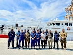 The USCGC Myrtle Hazard (WPC 1139) command stand for a photo with partners from the Papua New Guinea Defense Forces, Customs Services, National Fisheries Authority, and Department of Transport's maritime security division following an operational planning and subject matter exchange with partners in Port Moresby, Papua New Guinea on Aug. 22, 2023. The U.S. Coast Guard is in Papua New Guinea at the invitation of the PNG government to join their lead in maritime operations to combat illegal fishing and safeguard maritime resources following the recent signing and ratification of the bilateral agreement between the United States and Papua New Guinea. (U.S. Coast Guard photo by Chief Warrant Officer Sara Muir)