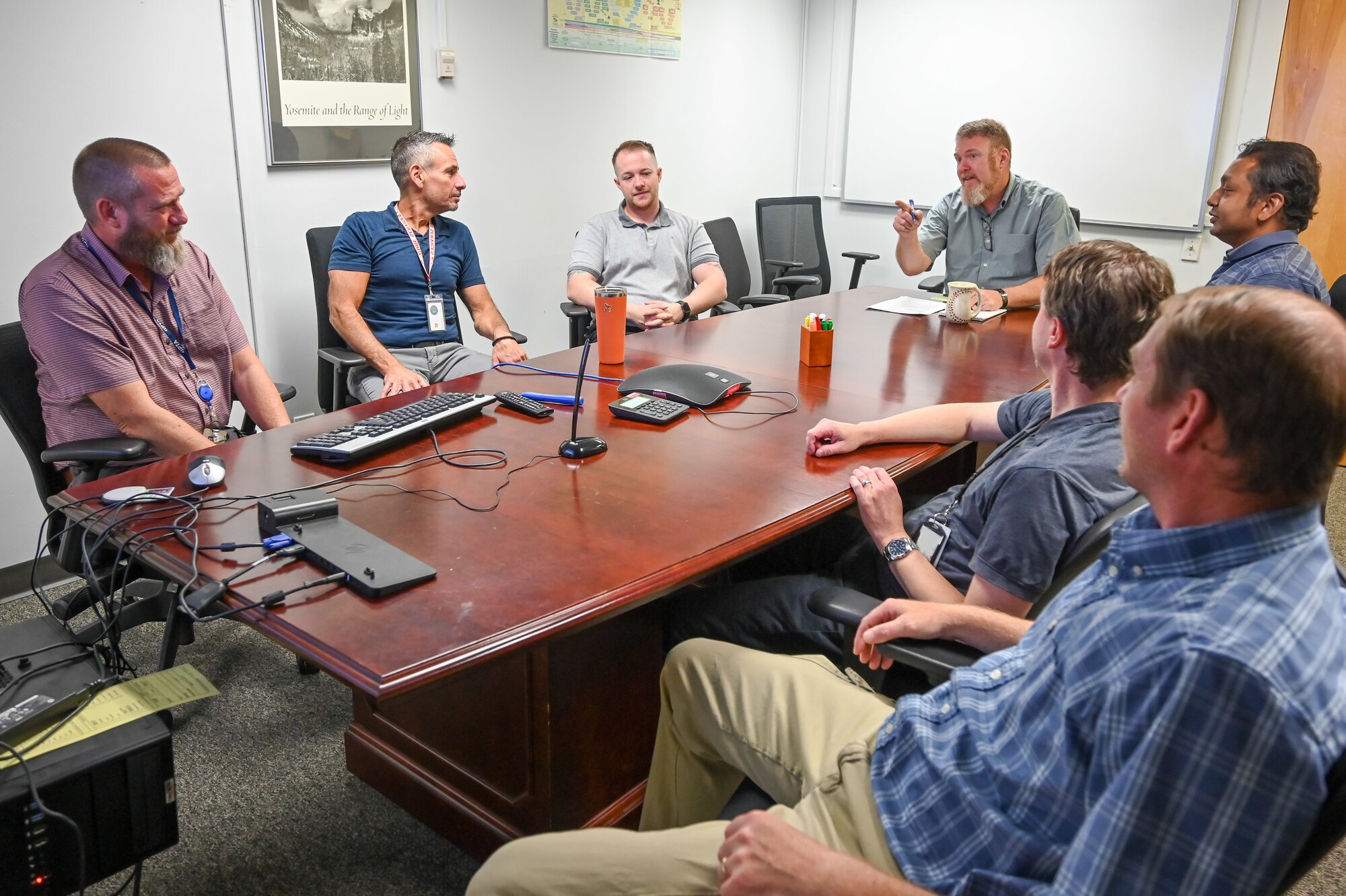 Seven Air Force civilians discuss around a conference table