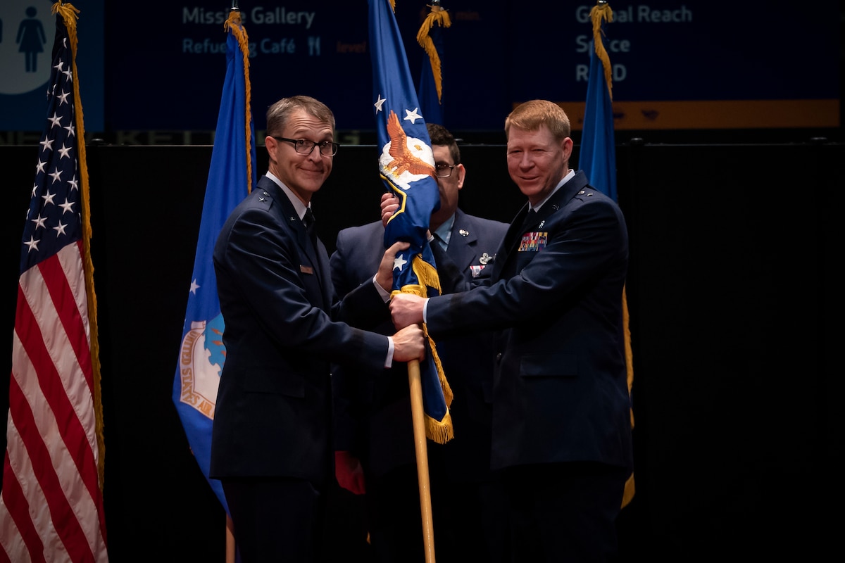 Brig. Gen. Scott A. Cain, left, commander, Air Force Research Laboratory, or AFRL, transfers command of AFRL’s 711th Human Performance Wing to Brig Gen. (Dr.) Robert K. Bogart, right, during an assumption of command ceremony while Senior Master Sgt. Michael Booth, superintendent of the AFRL Human Effectiveness Directorate, stands center at the National Museum of the U.S. Air Force, Aug. 21, 2023. (U.S. Air Force photo / Richard Eldridge)