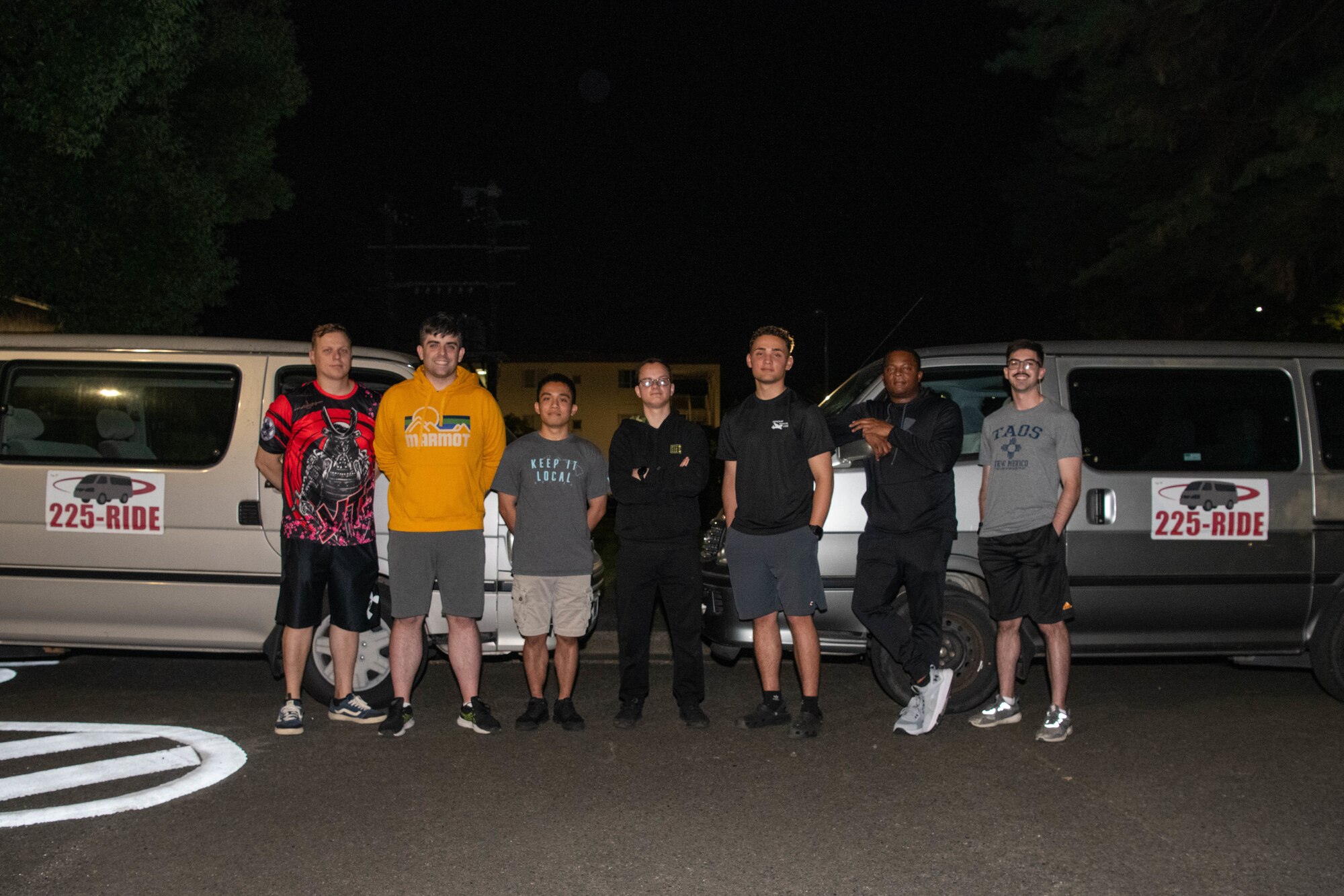 Group posed in front of vehicles