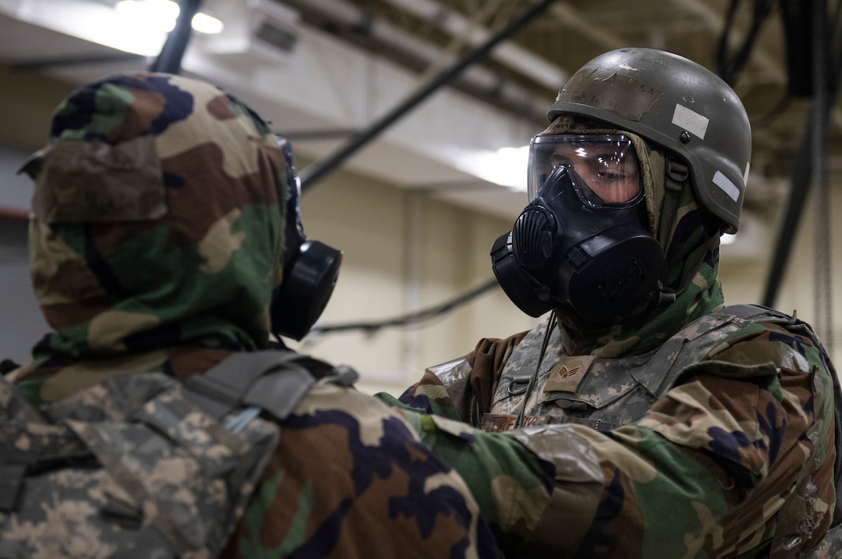 Senior Airman Danny Haskell receives a buddy check of his mission oriented protective posture gear by Senior Airman Zachary Tresik.