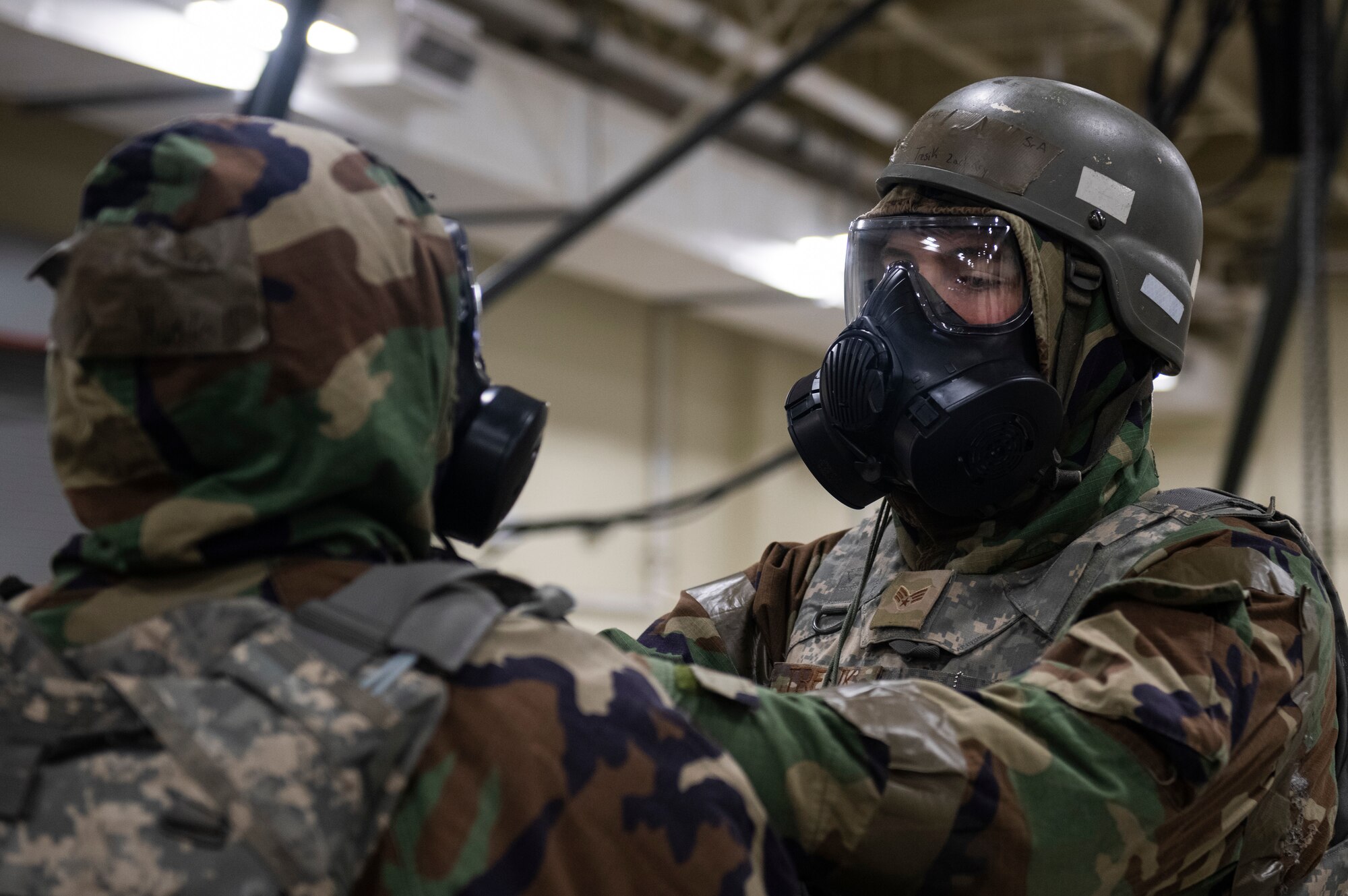Senior Airman Danny Haskell receives a buddy check of his mission oriented protective posture gear by Senior Airman Zachary Tresik.