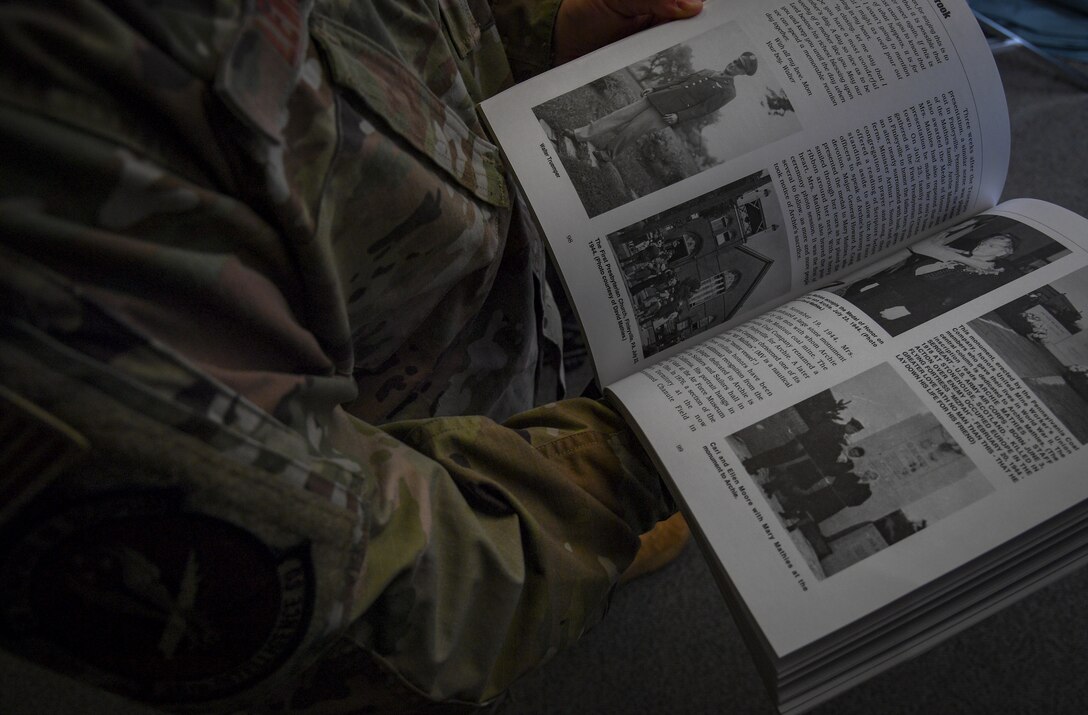 Military member opens a book and reads a page.
