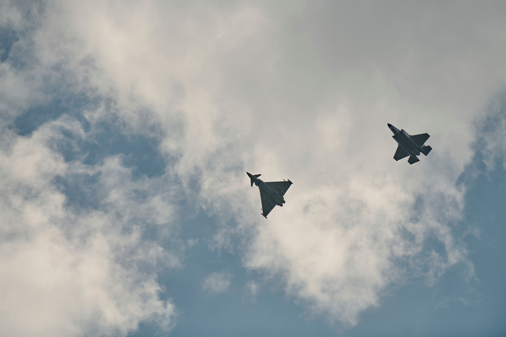Photo of an F-35A Lightning II from the Vermont Air National Guard's 158th Fighter Wing and a Eurofighter Typhoons from the Austrian Air Force's Airspace Surveillance Wing, flying over Hinterstoisser Air Base from the first ever training sortie between Vermont and Austria since signing their State Partnership Program agreement, Zeltweg, Austria, June 17, 2023.