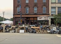 Photo of Piles of debris stacked up outside the Savoy Theatre after historic flooding in Montpelier, VT, July 18, 2023. The flooding is the worst in nearly a century and has impacted more than 120 towns and villages throughout the state. (U.S. Air Force photo by Tech. Sgt. Richard Mekkri)