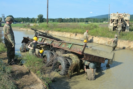 Soldiers attending the towing and recovery specialist course at the U.S. Army Reserve’s Regional Training Site – Maintenance at Fort Indiantown Gap conduct vehicle recovery training at FTIG’s mire pit on Aug. 22, 2023. The class included active-duty, Army Reserve and National Guard Soldiers. (Pennsylvania National Guard photo by Brad Rhen)