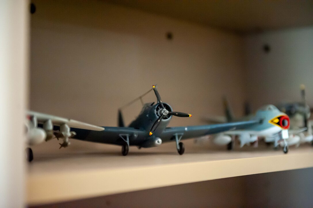 A Douglas Dauntless model airplane sits on display at the Joe D. Brown IV Mission Training Center on Ellsworth Air Force Base, South Dakota, Aug. 17, 2023. These models are organized and spread throughout the facility for visiting trainees to view as they conduct their training. Most of the model planes are hung from the ceiling as if in flight, however if they were modeled with landing gear deployed, they were most likely placed on a shelf or table as if parked. (U.S. Air Force photo by Spc3 Adam Olson)