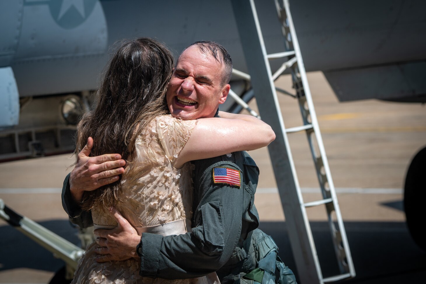Pilot hugs his wife in front of jets