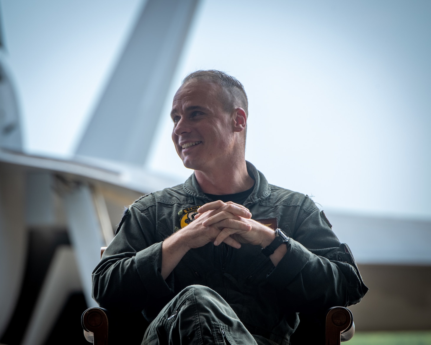 Pilot smiles while sitting in front of a jet