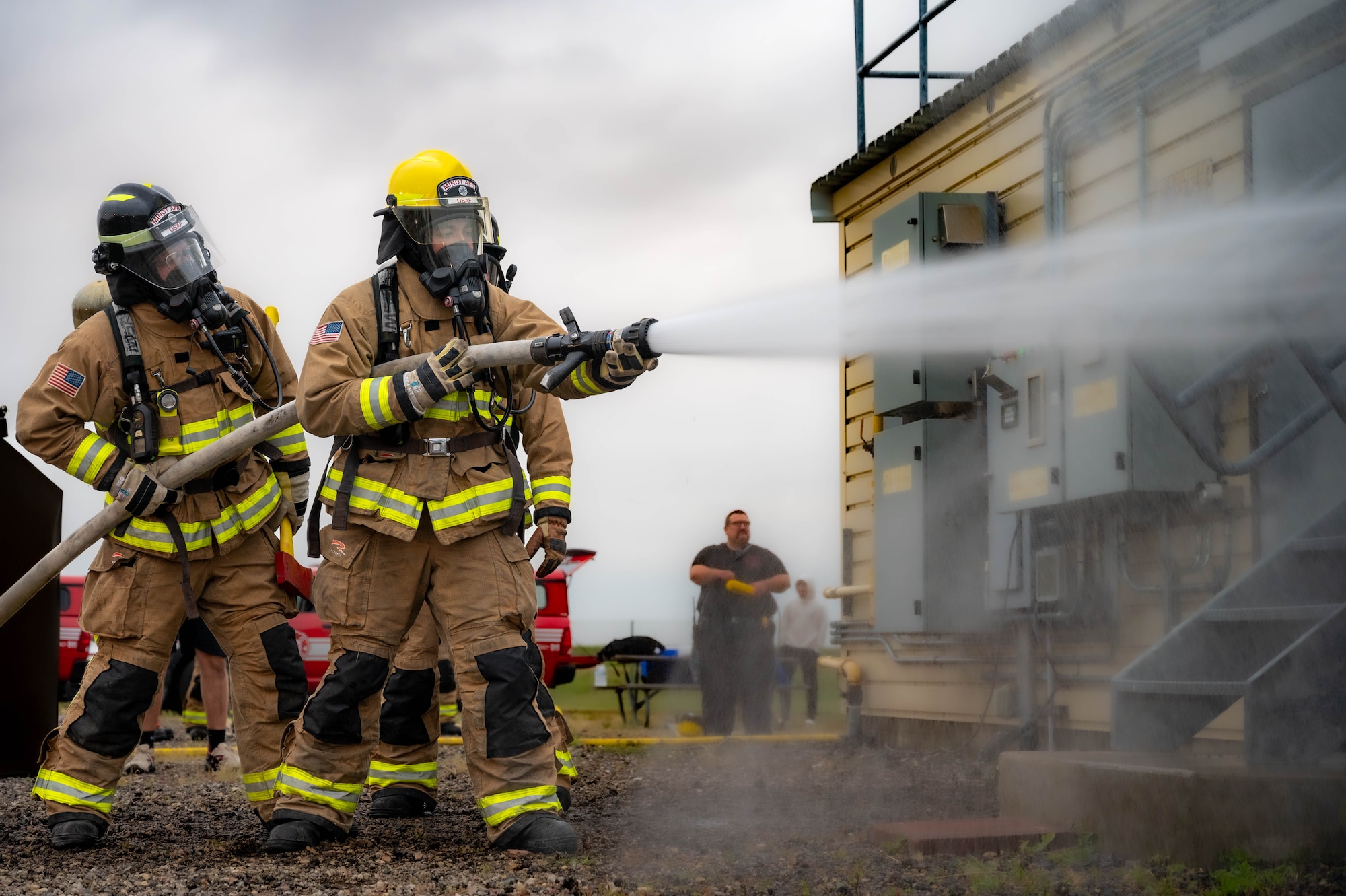 Airman Alberto Alvarez, 5th Civil Engineer Squadron fire protection specialist, tests the equipment before starting a live structure fire exercise at Minot Air Force Base, North Dakota, Aug. 21, 2023. The usual working pressure of a firehose can vary between 116 and 290 psi. (U.S. Air Force photo by Airman 1st Class Alexander Nottingham)
