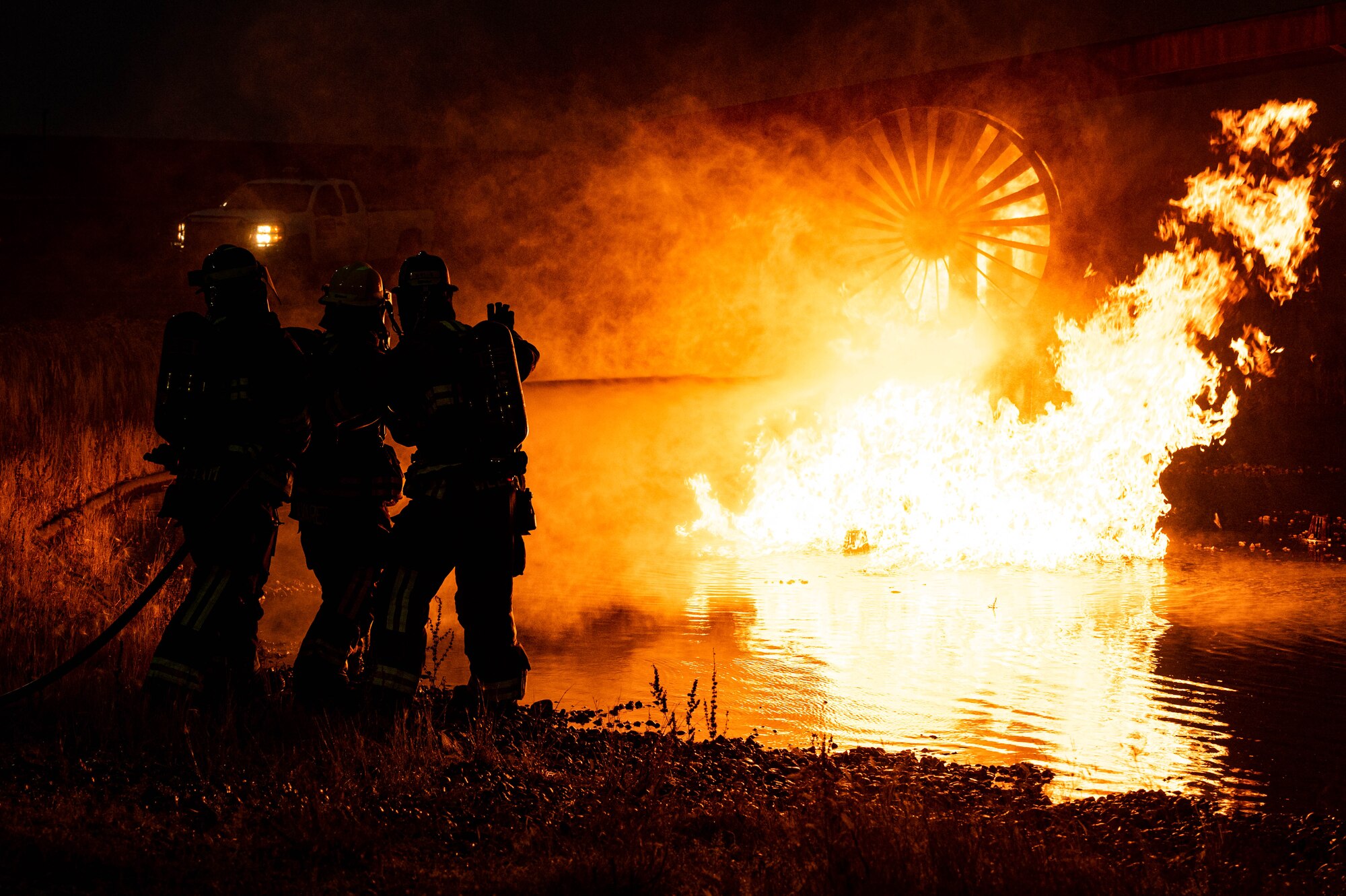 A group of 5th Civil Engineer Squadron fire protection specialists extinguish an ongoing fire during a live jet fire exercise Minot Air Force Base, North Dakota, Aug. 21, 2023. Fire Protection specialists can deal with everything from brush fires to burning rocket fuel and hazardous material fires, which makes frequent training a necessity. (U.S. Air Force photo by Airman 1st Class Alexander Nottingham)