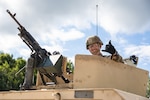 U.S. Army Pfc. Buckley Ryan, military police assigned to the 143rd Military Police Company, 192nd Military Police Battalion, Connecticut Army National Guard, poses for a photo from the turret of his High Mobility Multipurpose Wheeled Vehicle, or humvee, before vehicle gunnery at Fort Drum, New York, Aug. 13, 2023. Despite this being his first annual training period, and first time manning the M240L machine gun as a vehicle gunner, Ryan successfully engaged all targets and became the fifth gunner in his unit to qualify.