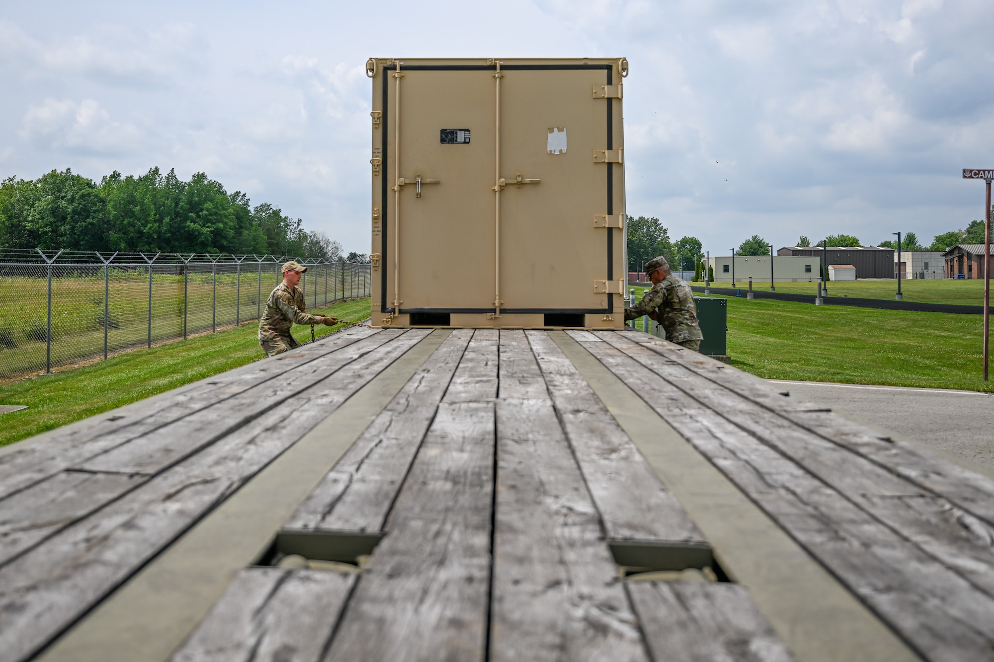 U.S. Air Force Senior Airman Aaron Razayeski, a Consolidated Asset Management Site ground transport specialist for the Innovative Readiness Training program, and Master Sgt. Daniel Payne, the CAMS warehouse manager for IRT, load a container onto a tractor-trailer, July 28, 2023, at Youngstown Air Reserve Station, Ohio.