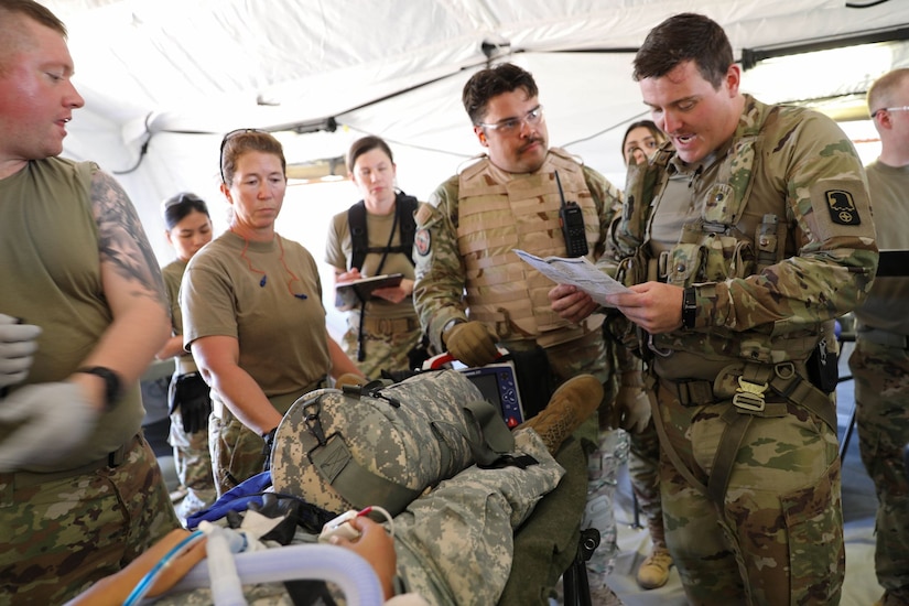 U.S. Army Reserve Spc. Adam Diefendorf, a critical care flight paramedic with 5-159th General Support Aviation Battalion, 244th Expeditionary Combat Aviation Brigade, Army Reserve Aviation Command, explains a casualty’s injuries to Air Force Reserve medical personnel from the 302nd Airlift Wing after a HH-60 MEDEVAC Black Hawk offload during exercise Mountain Medic at Fort Carson, Colorado, Aug. 14, 2023. Mountain Medic is an Army Reserve-led joint, multi-component, multi-domain aeromedical evacuation exercise geared at improving and reenforcing medical evacuation operations in a simulated large scale combat operations environment.