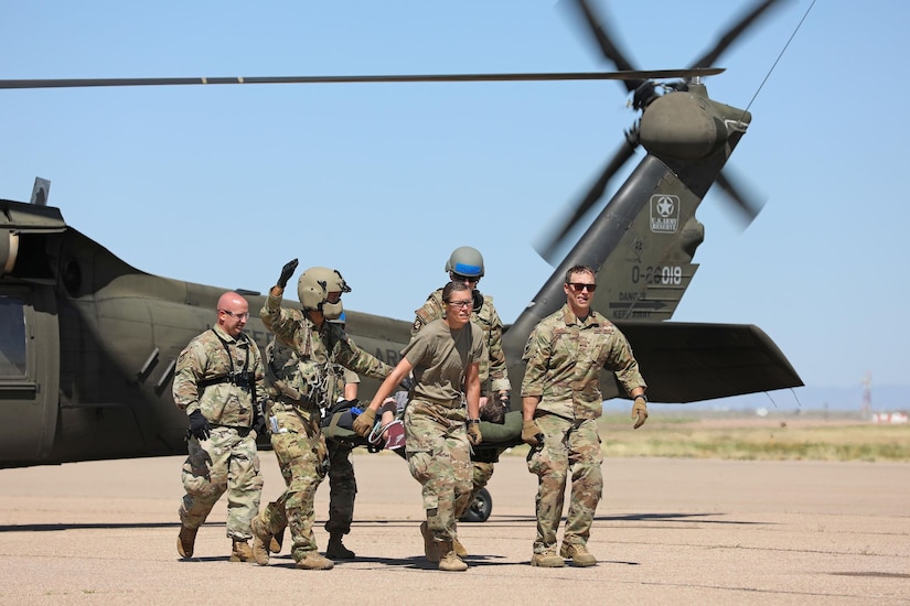 U.S. Army Reserve critical care flight paramedics from 5-159th General Support Aviation Battalion, 244th Expeditionary Combat Aviation Brigade, Army Reserve Aviation Command, work alongside Air Force Reserve medical personnel from the 302nd Airlift Wing to offload a casualty from a HH-60 MEDEVAC Black Hawk during exercise Mountain Medic at Fort Carson, Colorado, Aug. 15, 2023. Mountain Medic is an Army Reserve-led joint, multi-component, multi-domain aeromedical evacuation exercise geared at improving and reenforcing medical evacuation operations in a simulated large scale combat operations environment.