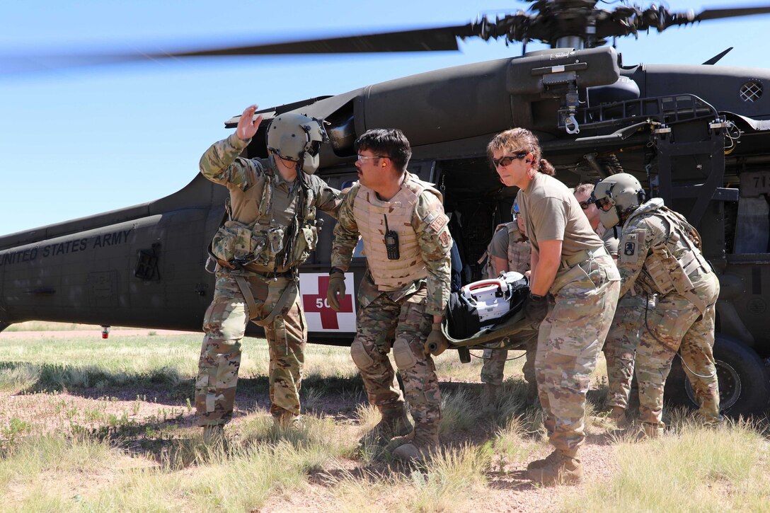 U.S. Army Reserve critical care flight paramedics from 5-159th General Support Aviation Battalion, 244th Expeditionary Combat Aviation Brigade, Army Reserve Aviation Command, guide Air Force Reserve medical personnel from the 302nd Airlift Wing in offloading a casualty from a HH-60 MEDEVAC Black Hawk during exercise Mountain Medic at Fort Carson, Colorado, Aug. 14, 2023. Mountain Medic is an Army Reserve-led joint, multi-component, multi-domain aeromedical evacuation exercise geared at improving and reenforcing medical evacuation operations in a simulated large scale combat operations environment.