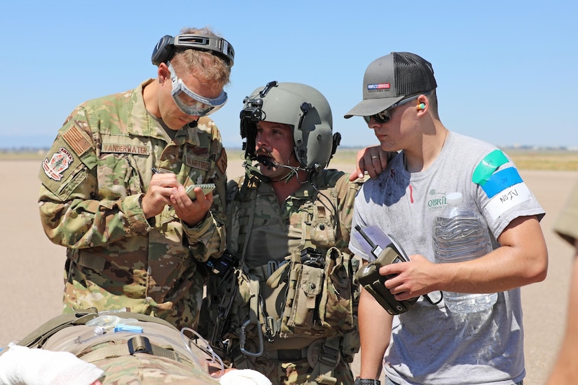 U.S. Army Reserve Staff Sgt. Daniel DiVincenzo, middle, a critical care flight paramedic with 5-159th General Support Aviation Battalion, 244th Expeditionary Combat Aviation Brigade, Army Reserve Aviation Command, explains a casualty’s injuries to Air Force Reserve medical personnel from the 302nd Airlift Wing after a HH-60 MEDEVAC Black Hawk offload during exercise Mountain Medic at Fort Carson, Colorado, Aug. 15, 2023. Mountain Medic is an Army Reserve-led joint, multi-component, multi-domain aeromedical evacuation exercise geared at improving and reenforcing medical evacuation operations in a simulated large scale combat operations environment.