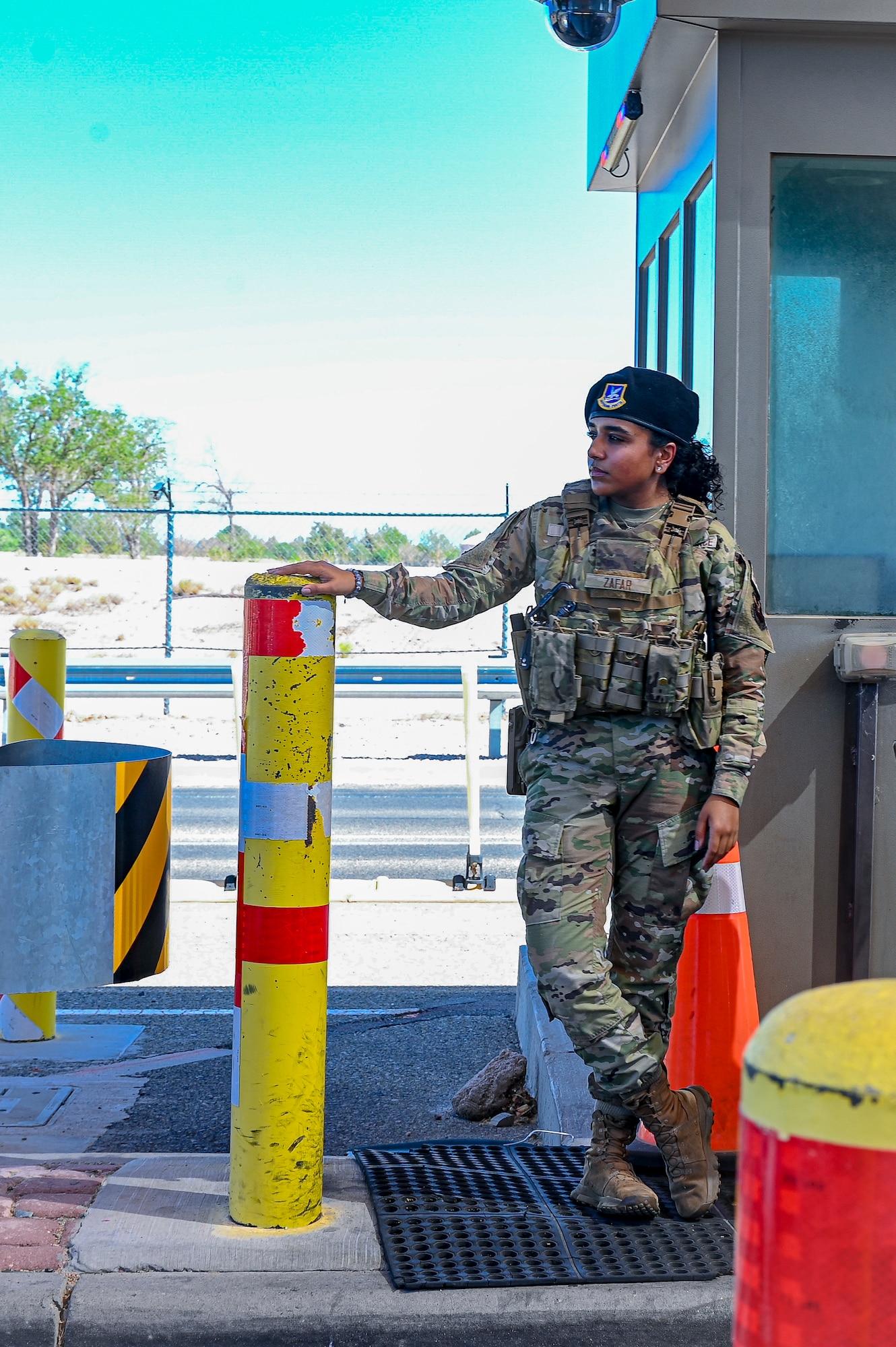 A woman stands at a gate.