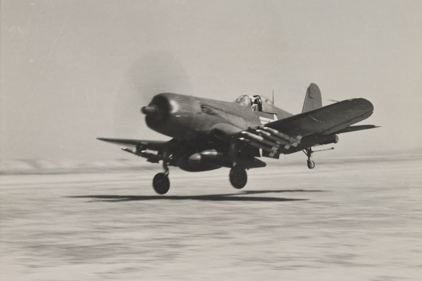 A single-engine propeller aircraft prepares to land on a runway.