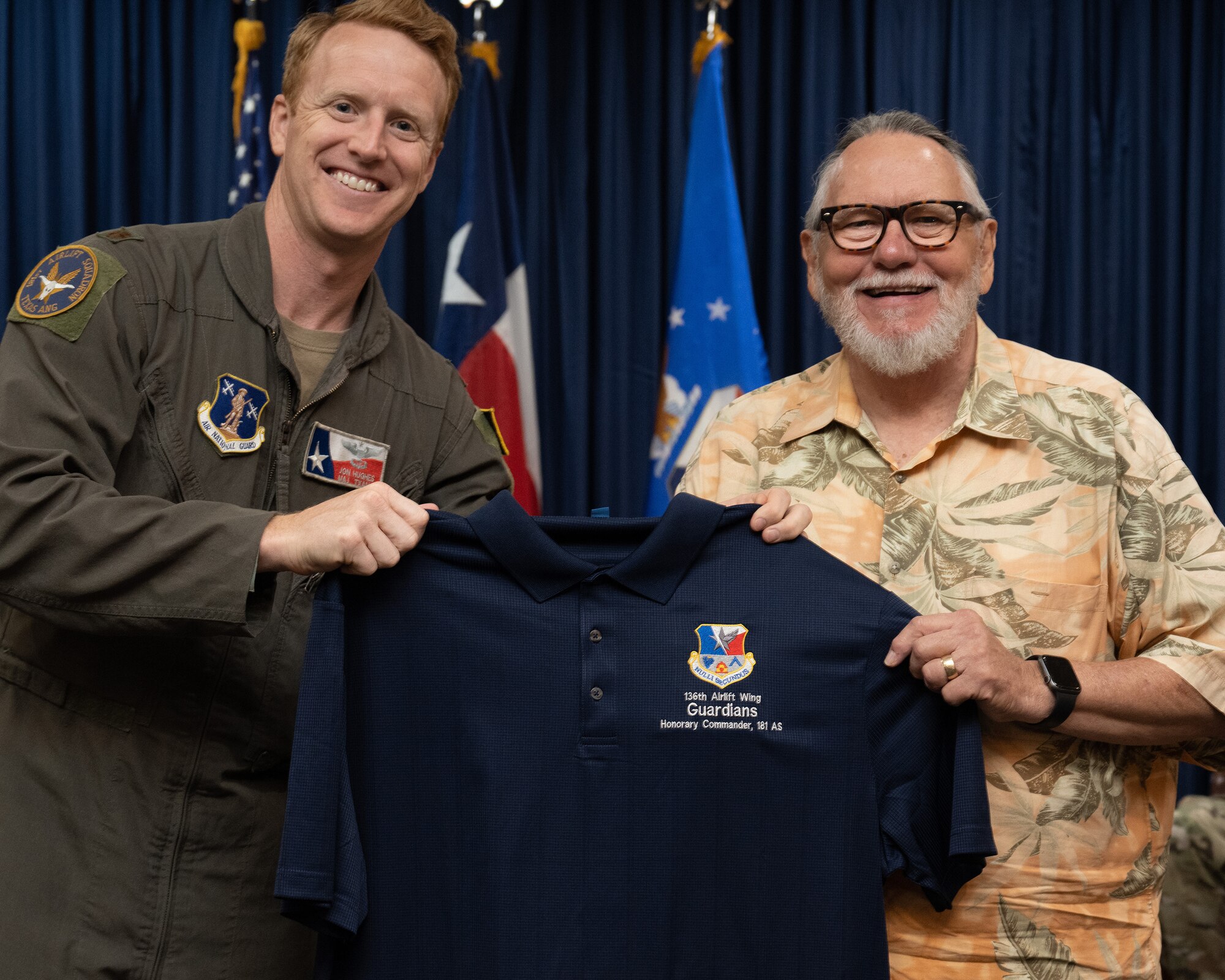 Two persons holding a guidon flag.