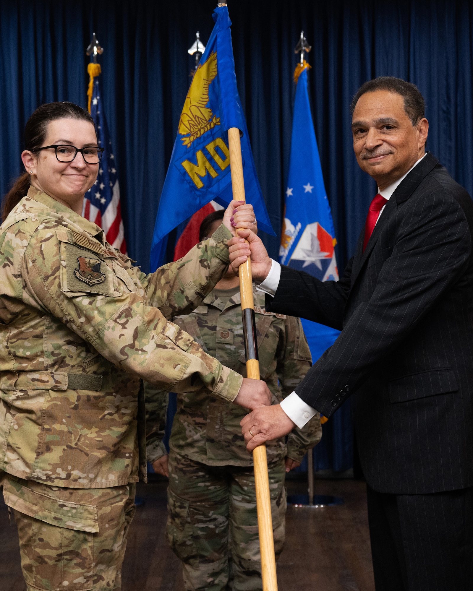 Two persons holding a flag, or certificate or shirt.