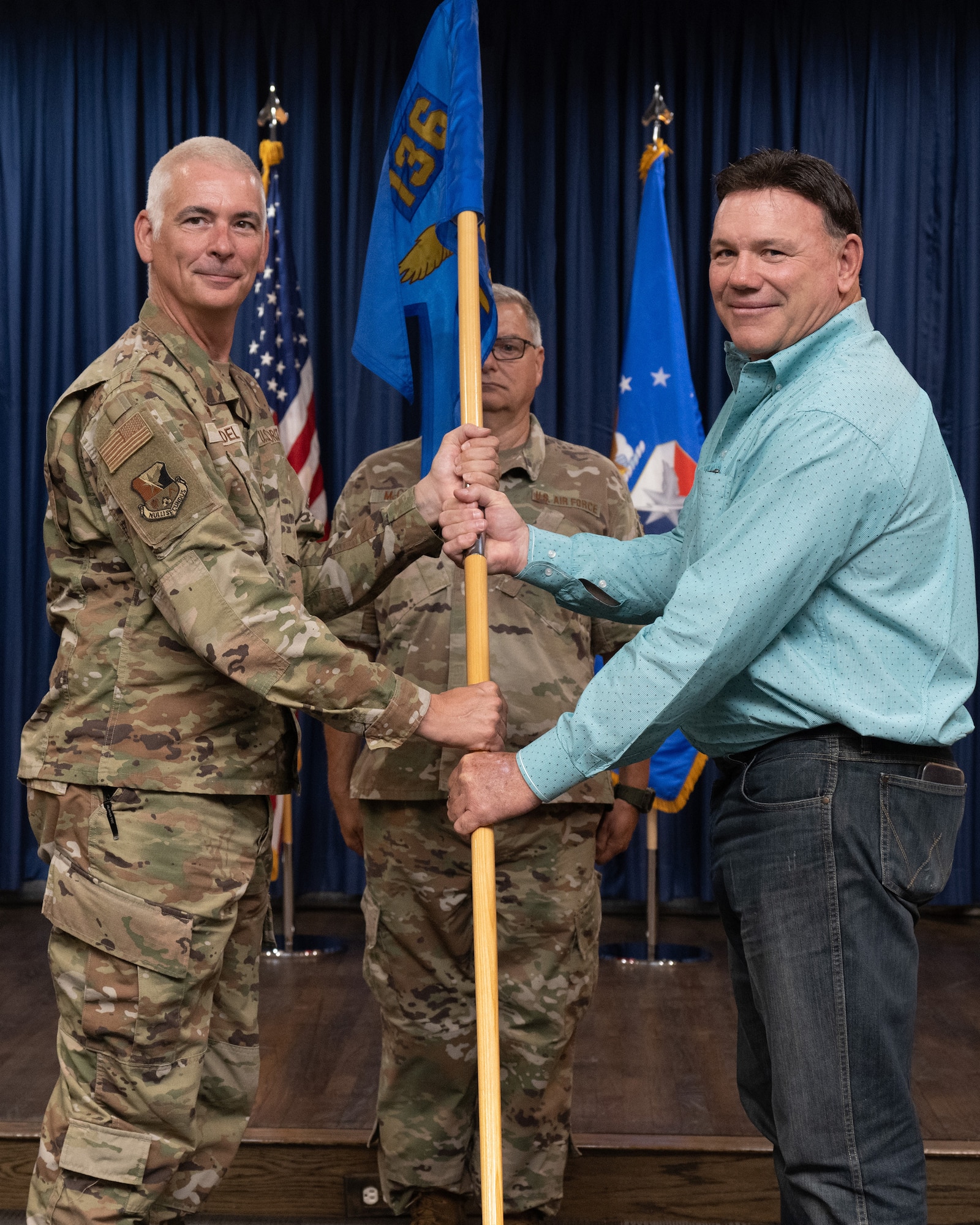 Two persons holding a flag, or certificate or shirt.