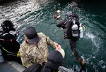 A Royal Australian Navy (RAN) Clearance Diver plunges into the Sydney Harbor to conduct a simulated hull search exercise with U.S. Navy Explosive Ordnance Disposal Mobile Unit 5 Sailors in Sydney, Australia, during Exercise Malabar 2023, August 15. This iteration of Malabar is the first year with Australia as the host country. Malabar 23 is a surface, air, and subsurface multilateral field training exercise conducted with RAN, Indian Navy, Japan Maritime Self-Defense Force, and U.S. Navy that enhances interoperability and strengthens ties and critical partnerships between the maritime forces and demonstrates the countries commitment to the Indo-Pacific region.